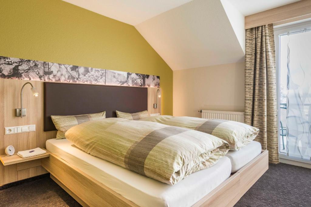 - une chambre avec un grand lit et une grande fenêtre dans l'établissement Landpension Kohler, à Brackenheim