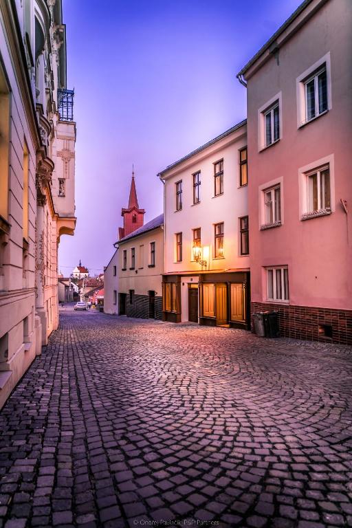 brukowana ulica z budynkami i wieżą zegarową w obiekcie Lucerna - dům s duší Příbor w mieście Příbor