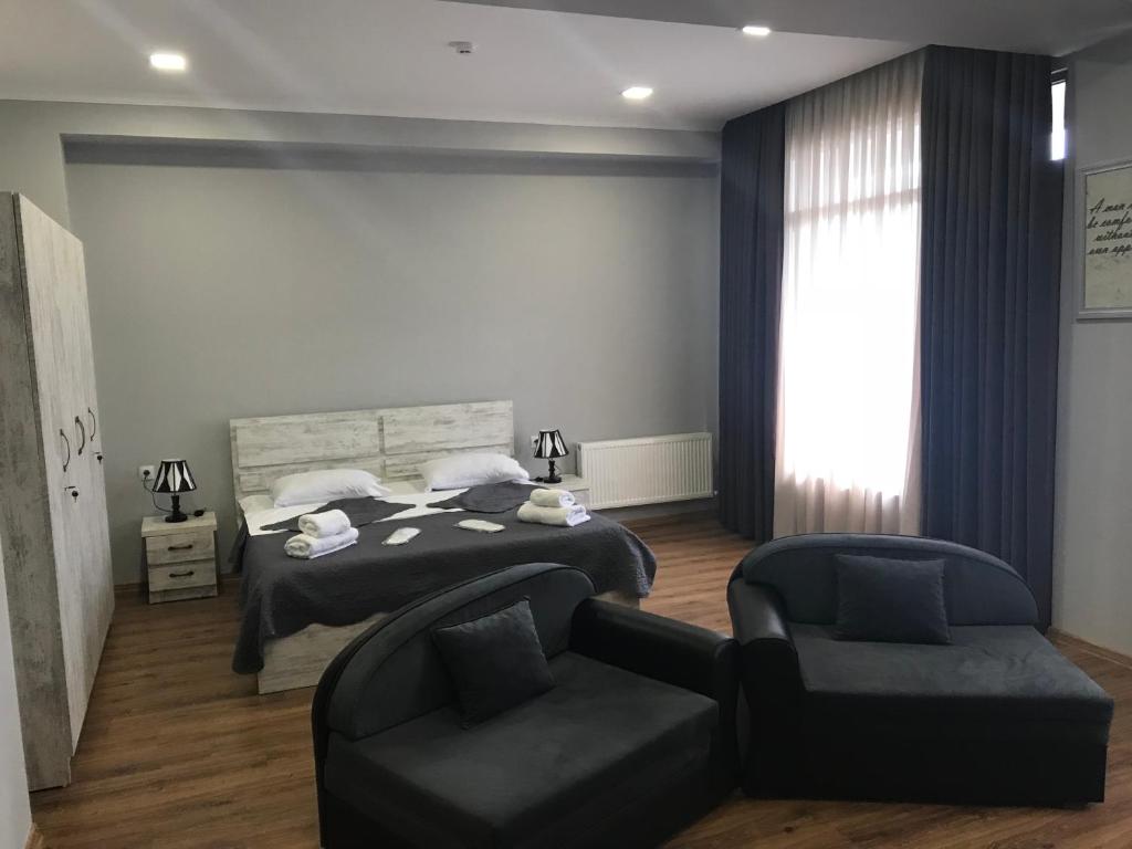 1 dormitorio con 1 cama, 1 silla y 1 sofá en Apart Hotel Vera, en Tiflis