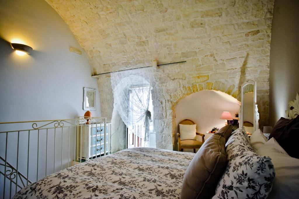 una camera con un grande letto in una parete in pietra di La Dimora U Curdunn a Locorotondo