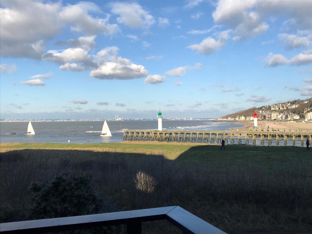 ドーヴィルにあるAu petit port de Deauville - studio avec vue merの灯台とヨットのあるビーチの景色