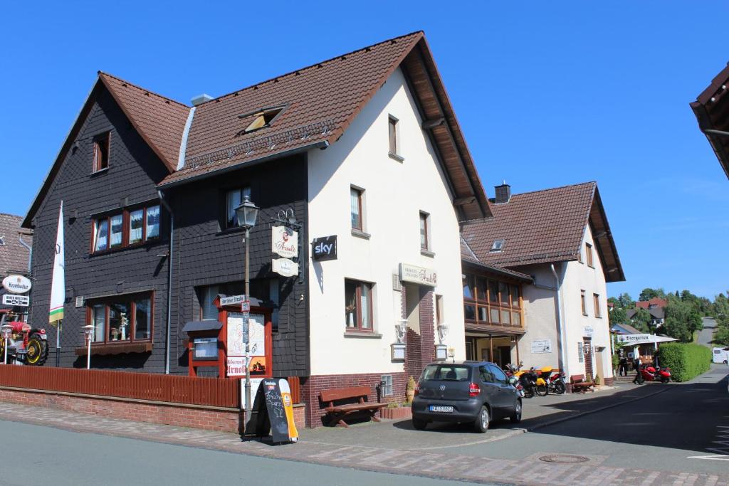 a white and black building on a city street at Landgasthof-Bikerhotel Arnold in Battenberg