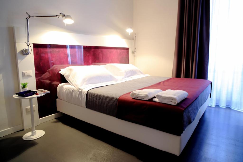 a bedroom with a bed with two towels on it at Inn Urbe Colosseo in Rome