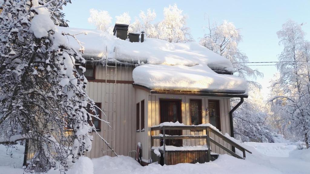 a house with snow on the roof at Berry Apartments in Rovaniemi