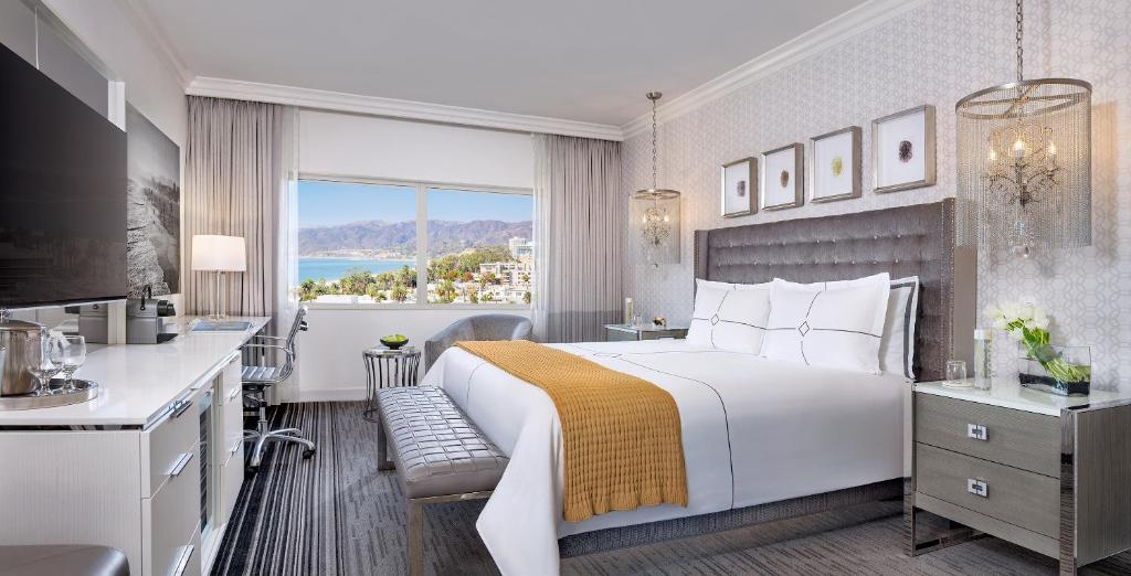 ロサンゼルスにあるハントリー サンタ モニカ ビーチの大きなベッドとキッチンが備わるホテルルームです。