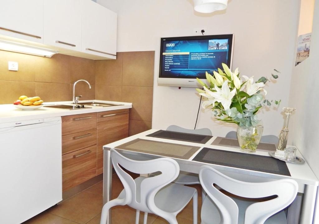 cocina con mesa y TV en la pared en Guest House Varos, en Split