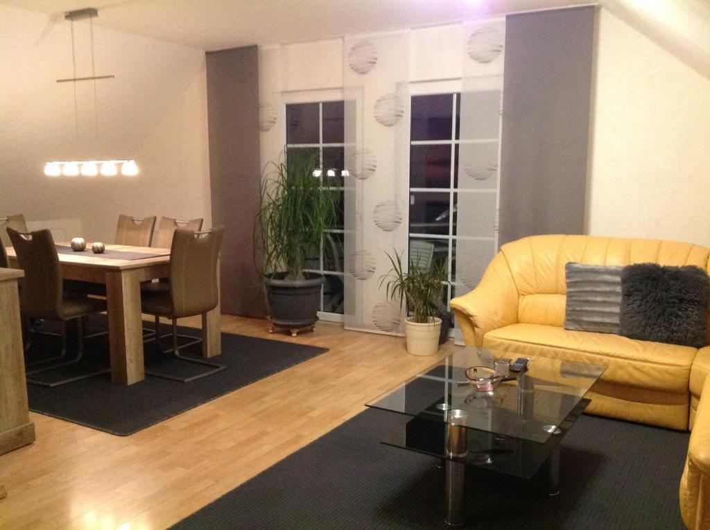 a living room with a yellow couch and a table at Ferienwohnung "Deluxe" in Korbach in Korbach