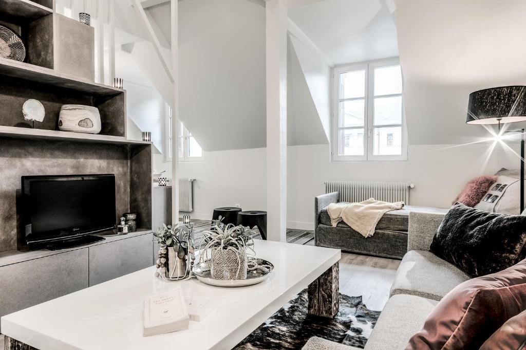 uma sala de estar com um sofá e uma mesa em La Gloriette em Annecy