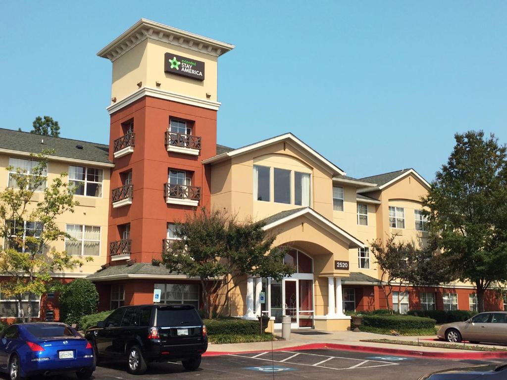 un edificio con coches estacionados en un estacionamiento en Extended Stay America Suites - Memphis - Wolfchase Galleria, en Memphis