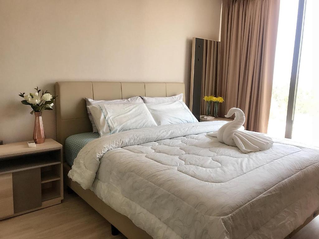 um quarto com uma cama branca com um cisne em The Pine Hua Hin em Hua Hin