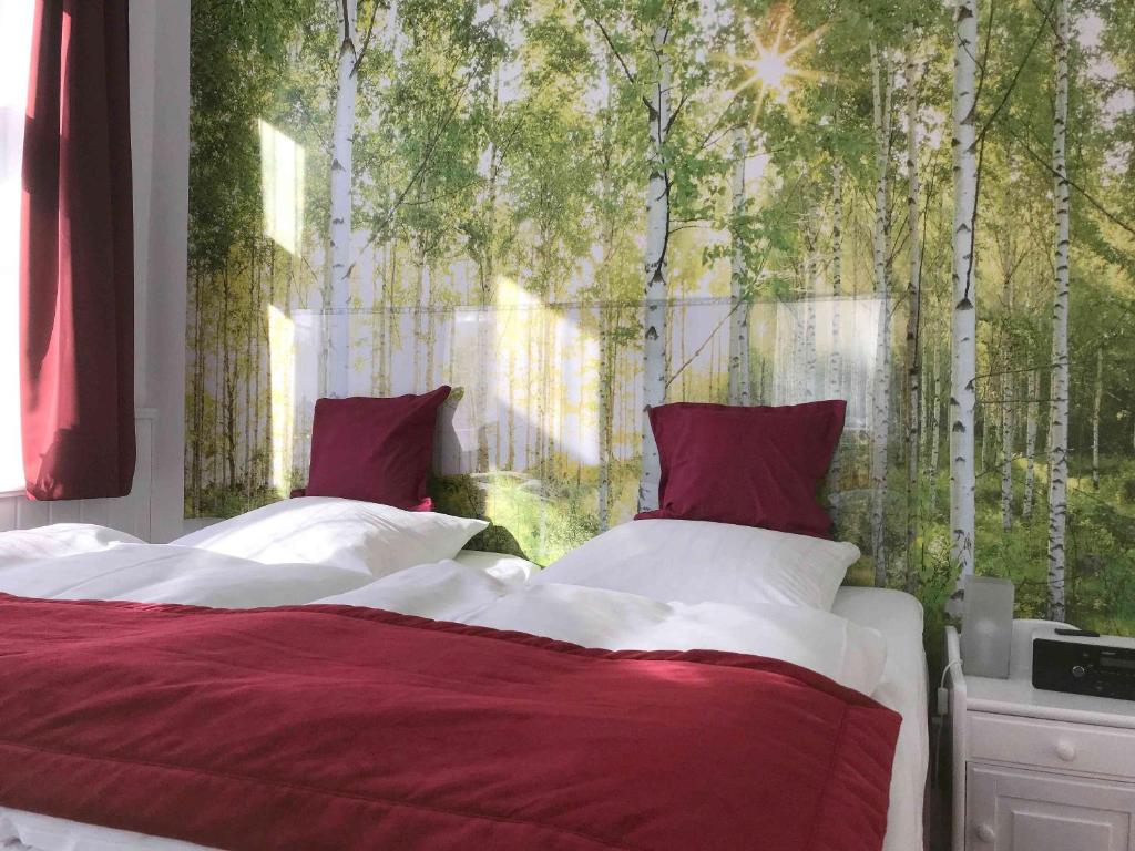 a bedroom with two beds and a window with trees at Henne Hahnenklee in Hahnenklee-Bockswiese