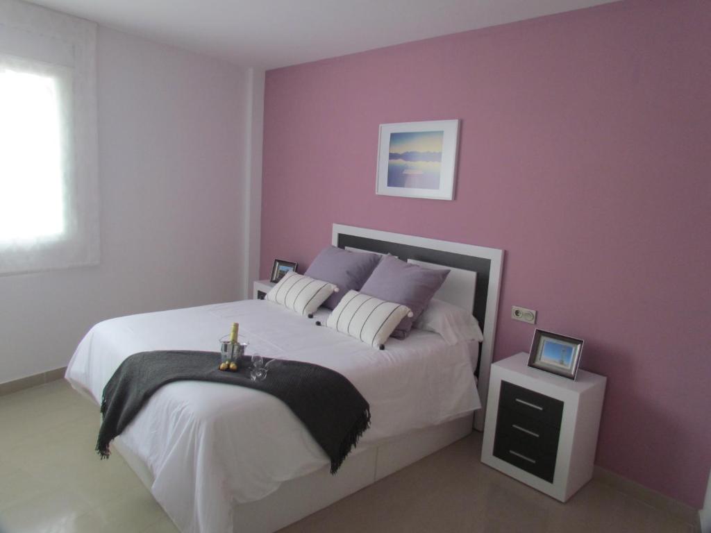 a bedroom with a large bed with purple walls at Lo Xalador-Delta d'Ebre in Deltebre