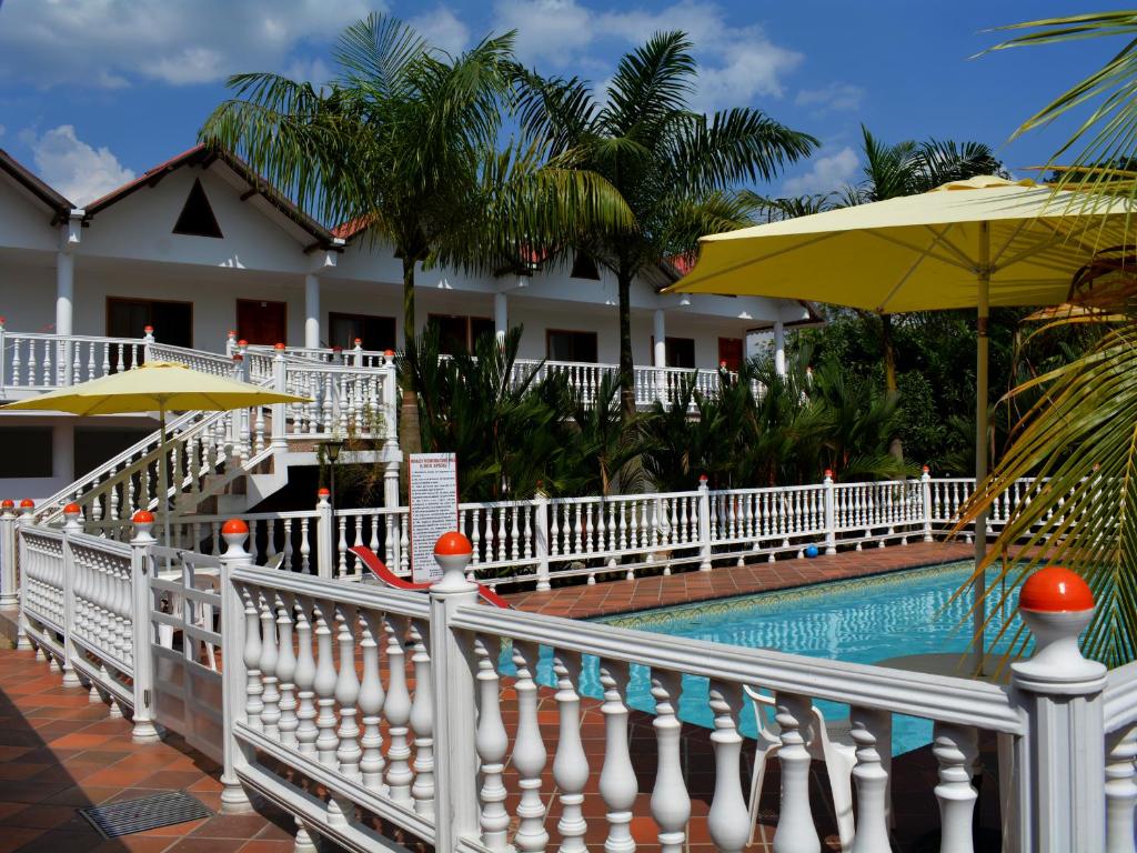 un complejo con piscina y valla blanca en Hotel Campestre La Toscana en Villavicencio