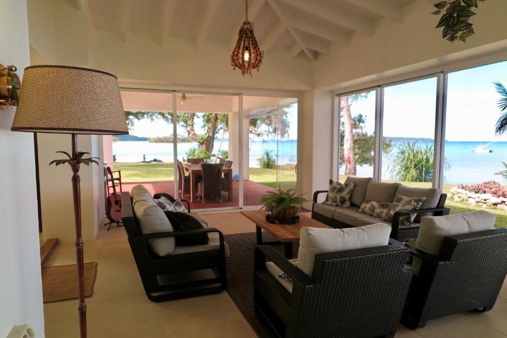 a living room with a couch and chairs and a table at Ocean Point Villa in Saraotou