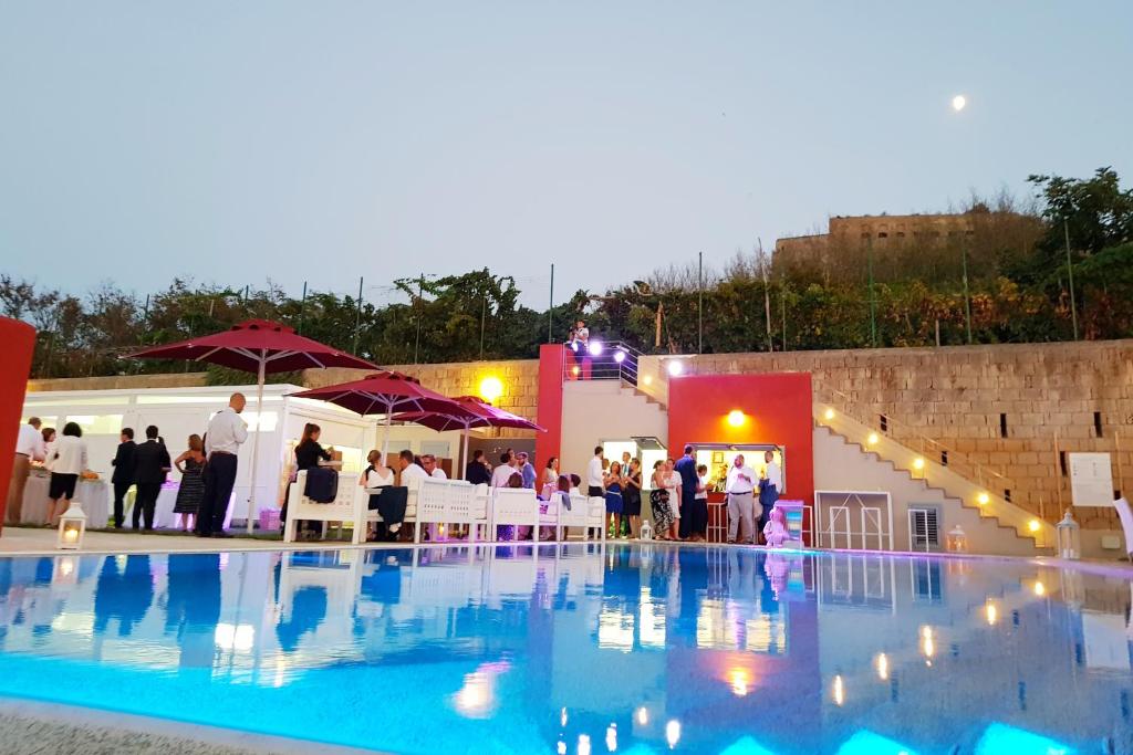 a group of people standing next to a swimming pool at Albergo 'La Vigna' in Procida