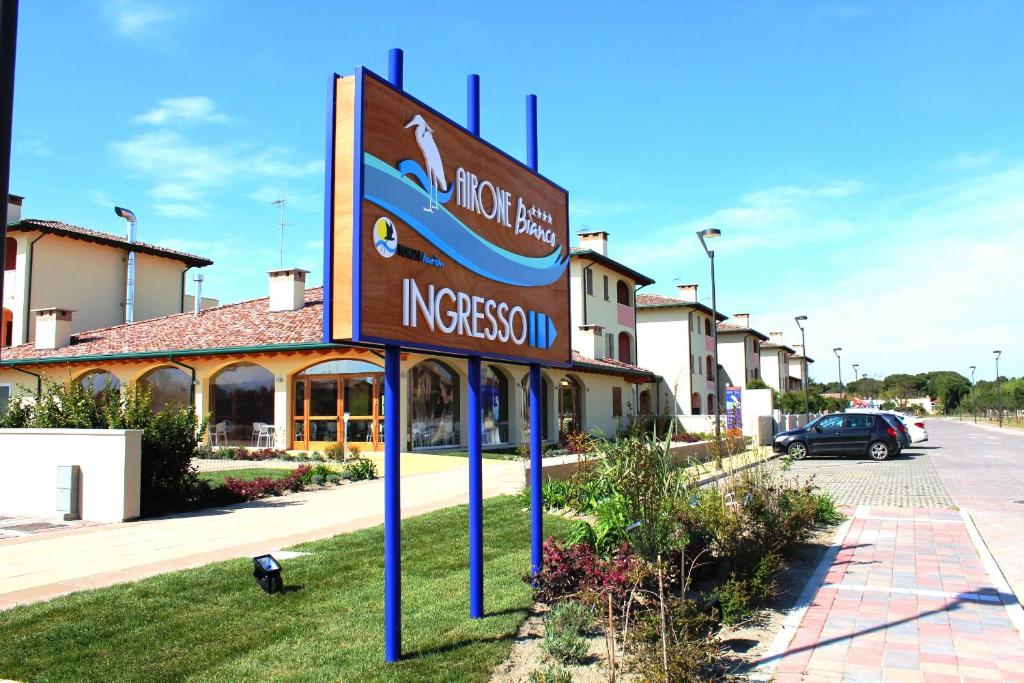 a sign in the grass in front of a building at Airone Bianco Residence Village in Lido delle Nazioni