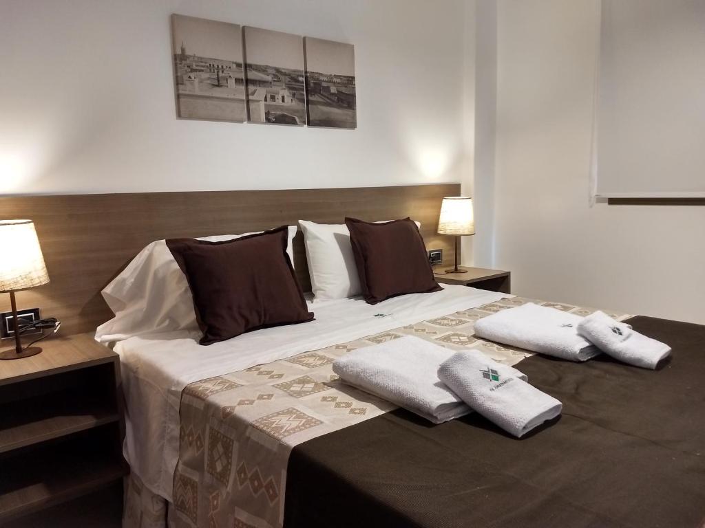 a bedroom with a large bed with two pillows on it at XV Apartamentos in La Plata