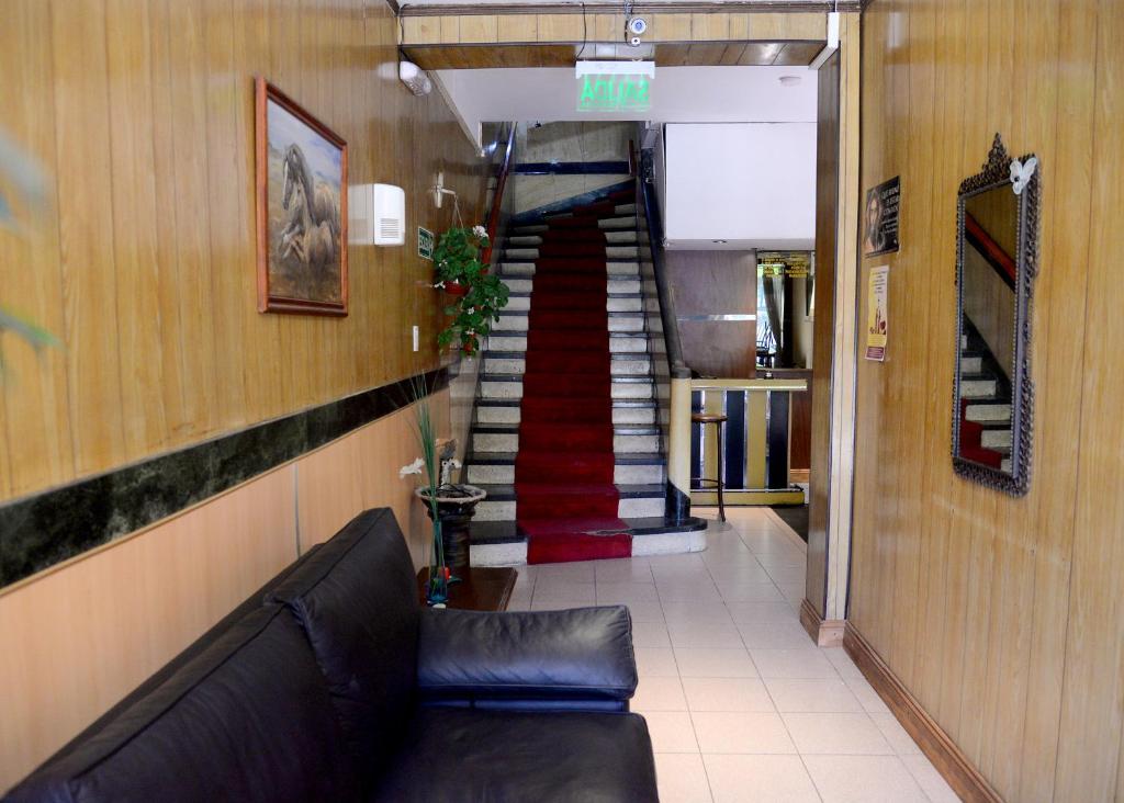 マル・デル・プラタにあるHotel Danteのソファと螺旋階段のあるリビングルーム