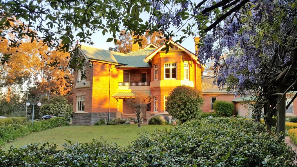 una gran casa amarilla con un gran patio en Blair Athol Homestead, en Inverell