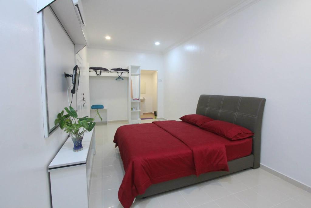 a bedroom with a bed with a red blanket at The Sofea Inn Transit Room Airport Kota Bharu in Pengkalan Cepa