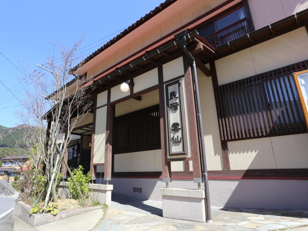a building with a sign in front of it at Minshuku Unzen in Unzen