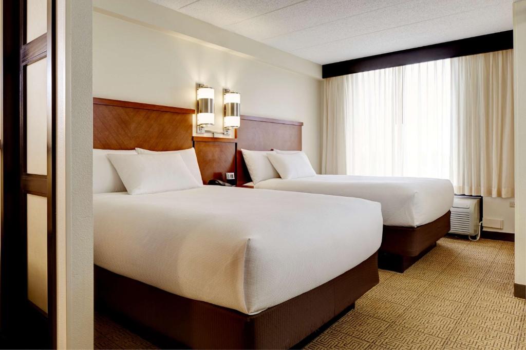 a hotel room with two beds and a window at Hyatt Place Atlanta Buckhead in Atlanta