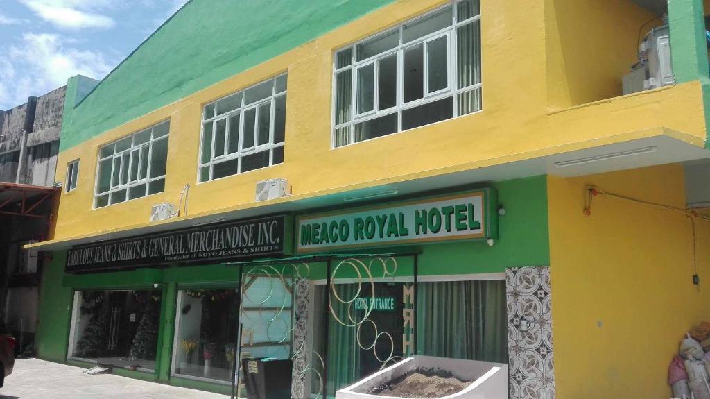 a yellow and green building on a street at Meaco Royal Hotel - Tabaco in Tabaco