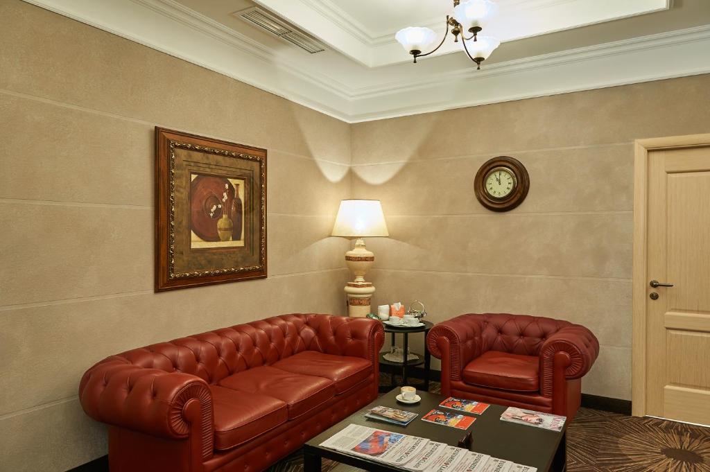 a living room with two leather chairs and a table at ASTOR Hotel in Perm