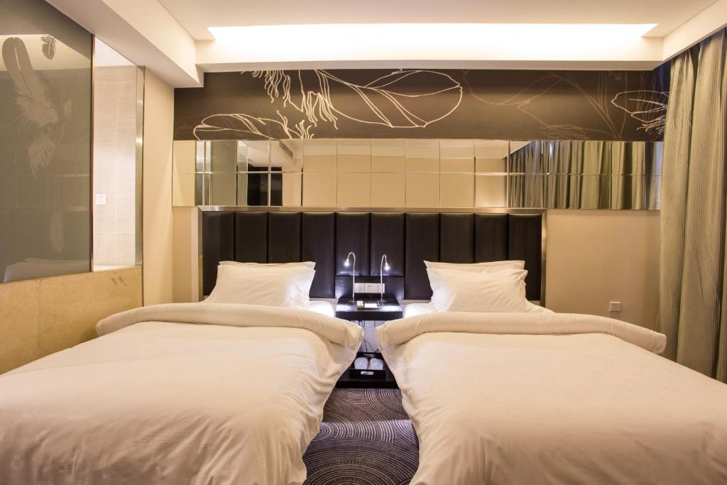2 camas en una habitación de hotel con mesa en Metropolo, Hefei, Wanda Plaza, Swan Lake, en Hefei