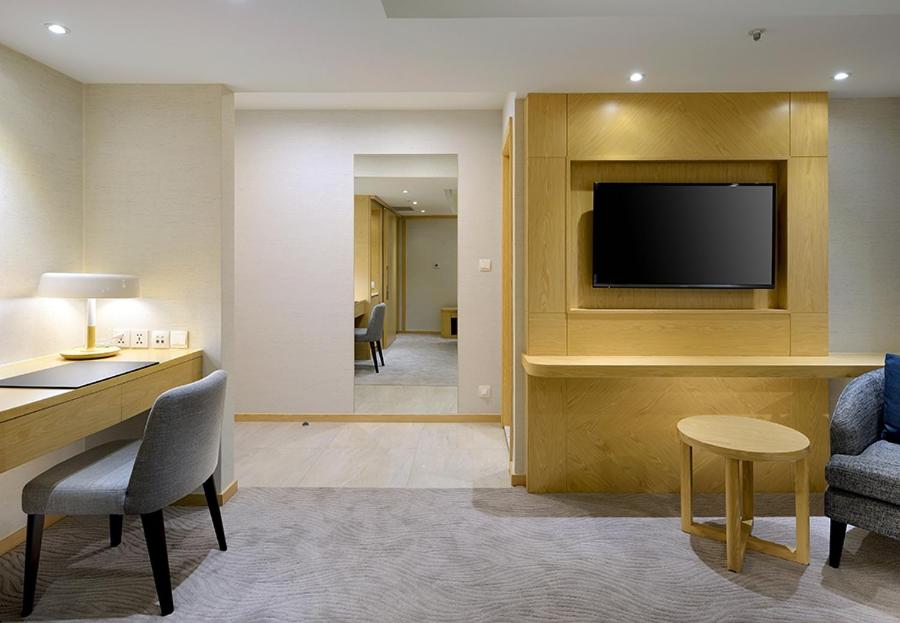 a living room with a tv and a table and chairs at Sonnien Hotel in Taipei