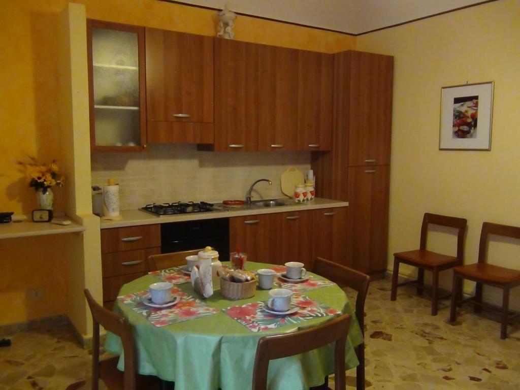チェファルにあるTití e Totò houseのキッチン(テーブル、緑のテーブルクロス付)