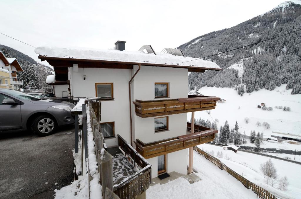 ein Haus im Schnee mit einem Auto daneben geparkt in der Unterkunft Haus Ladner - Josef und Marianne in Kappl