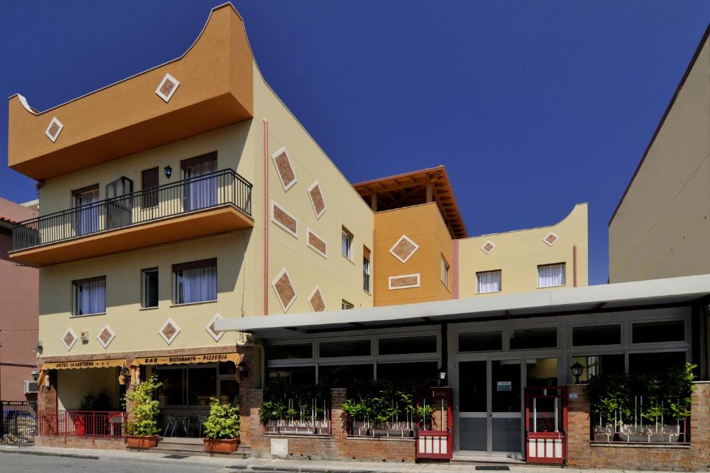 un gran edificio con ventanas y balcones. en La Lanterna Hotel en Rometta Marea