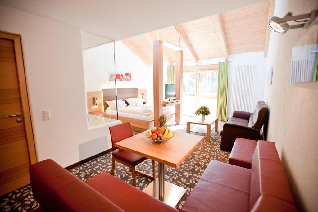 a living room with a couch and a table at Hotel und Appartementhof Waldeck in Bad Füssing