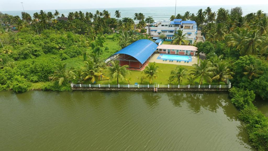 uma vista aérea de uma casa ao lado de uma massa de água em Blue Waters Cherai em Cherai Beach