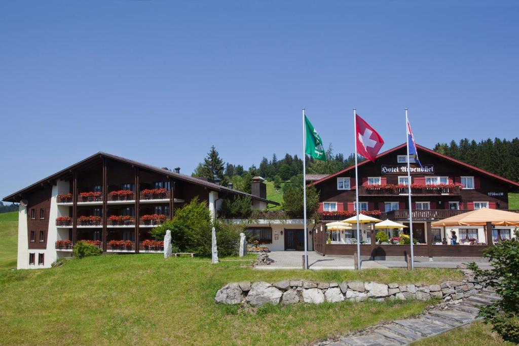 ein großes Gebäude mit Flaggen davor in der Unterkunft Hotel Arvenbüel in Amden