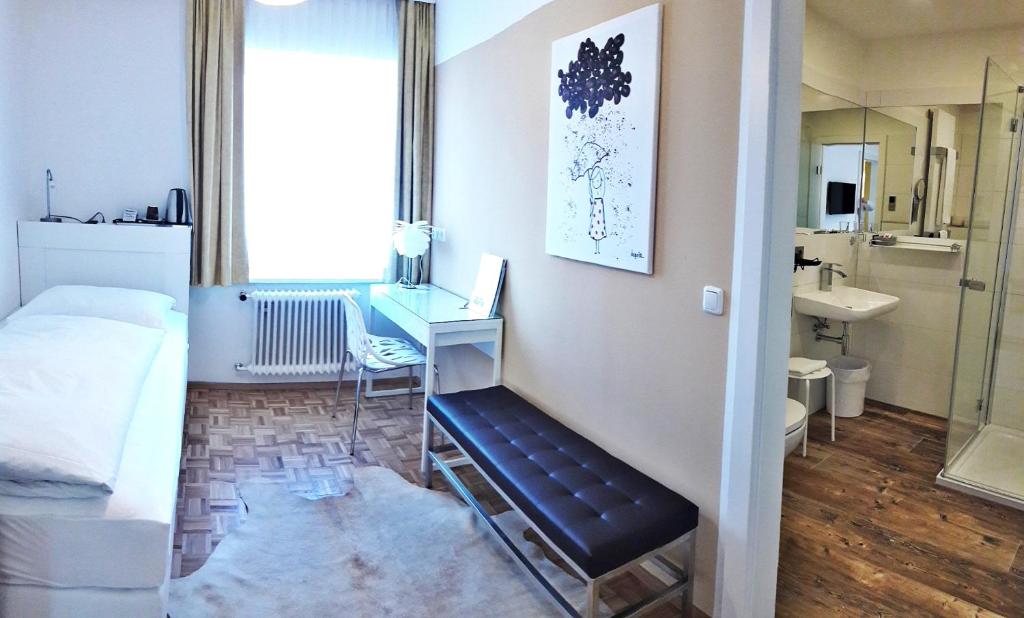 um quarto com uma cama, uma secretária e um lavatório. em Boutique Hotel Oase em Bad Ischl