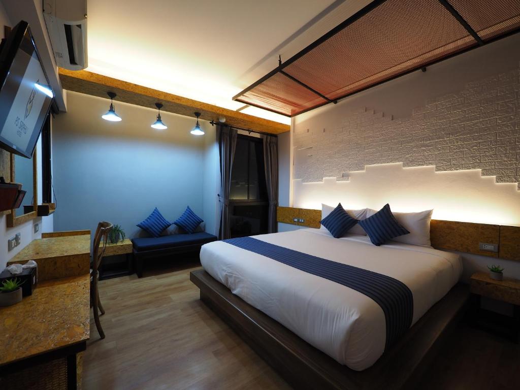 a bedroom with a large bed with blue pillows at Ps Sriphu Hotel in Hat Yai