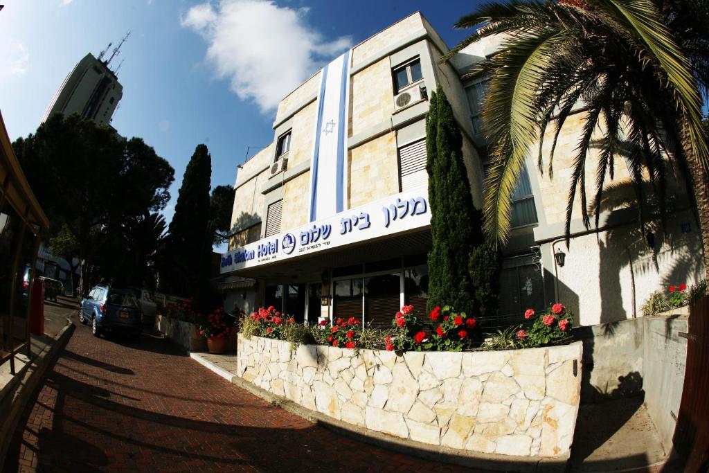 un edificio con flores frente a un edificio en Beth-Shalom, en Haifa