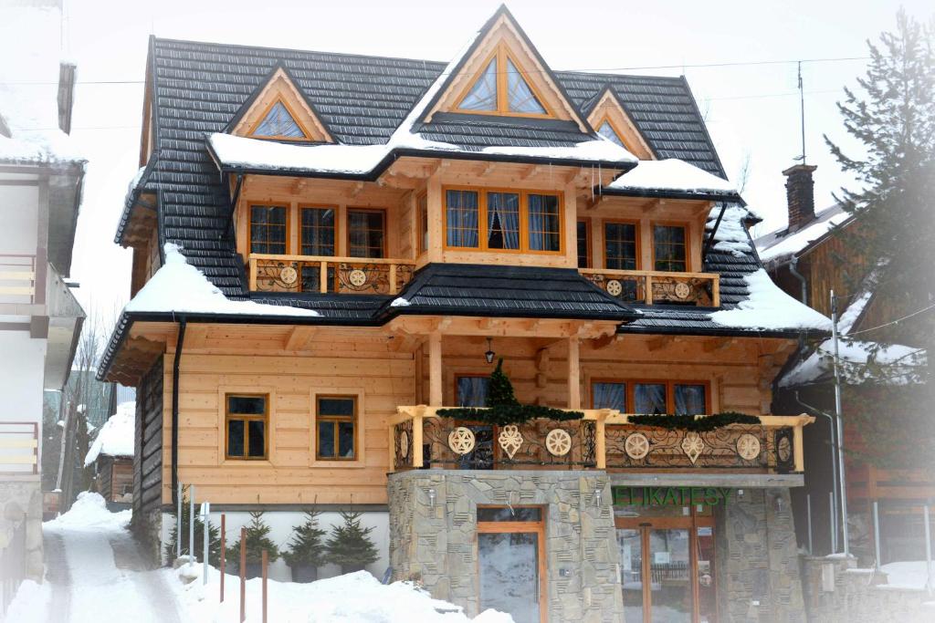 a wooden house with snow on top of it at Willa Waja in Suche