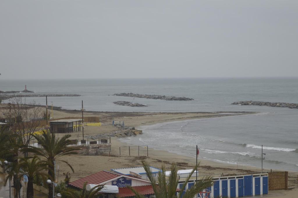 a view of a beach with houses and the ocean at Hotel Svizzera in Arma di Taggia