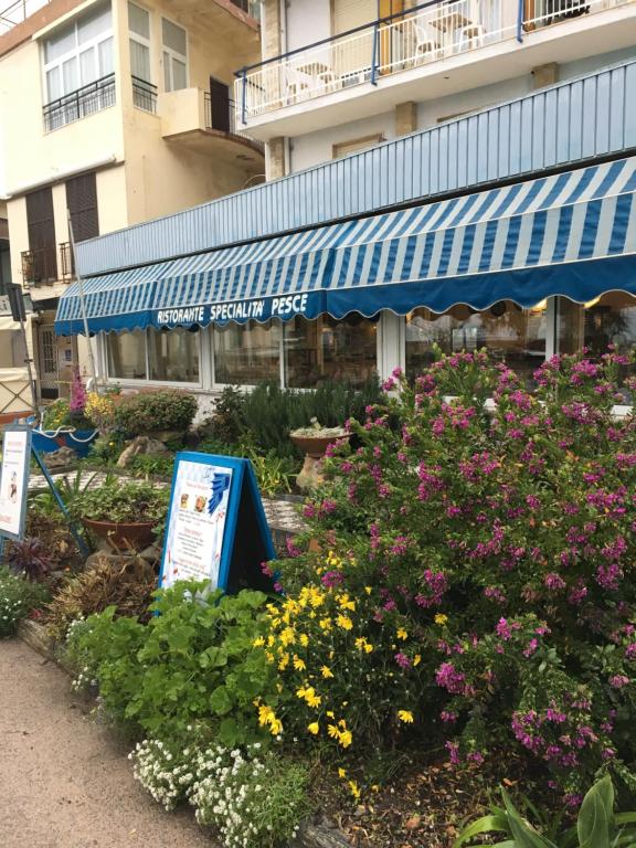 a garden in front of a building with flowers at Hotel Svizzera in Arma di Taggia