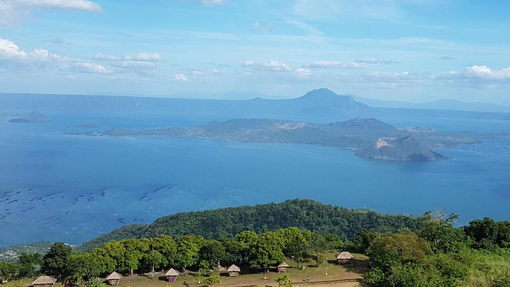 Blick auf einen großen Wasserkörper mit Häusern und Bäumen in der Unterkunft Elizabeth 1829 @ Wind Residences in Tagaytay