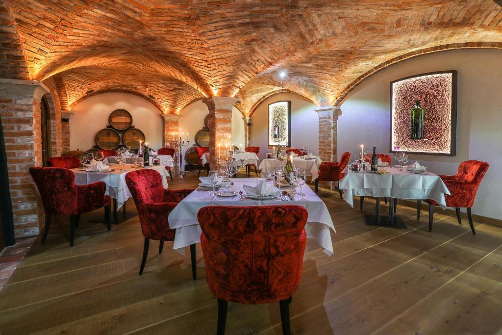 a dining room with white tables and red chairs at Verwöhnhotel Kristall in Pertisau