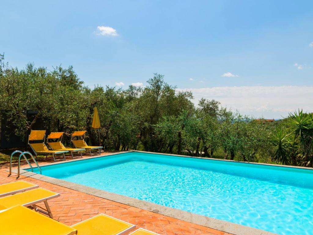 a swimming pool with yellow chairs and a swimming pool at Belvilla by OYO Nice Farmhouse with Sauna Jacuzzi in Pieve a Nievole