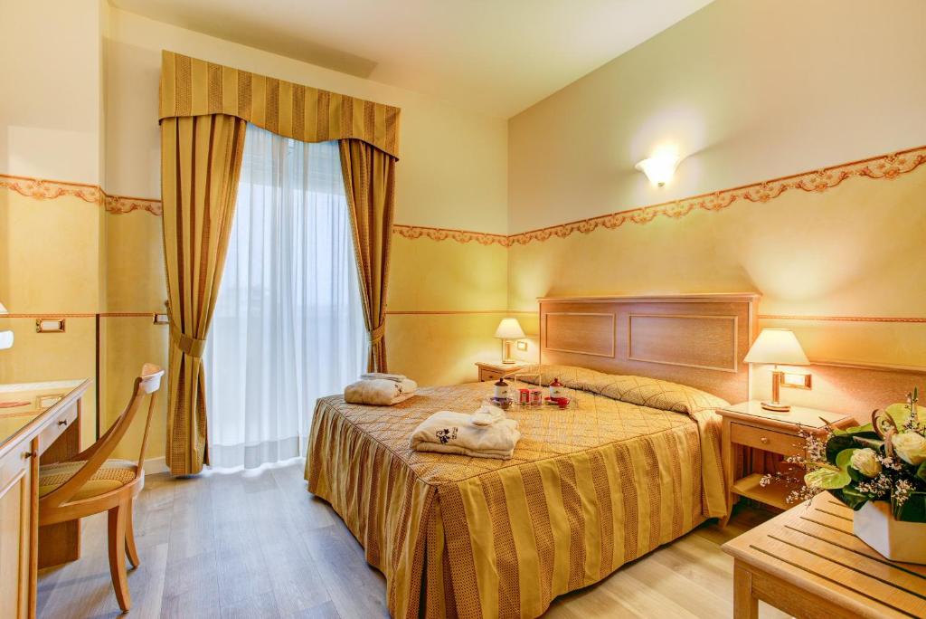 una camera d'albergo con letto e scrivania di Hotel Byron a Rimini