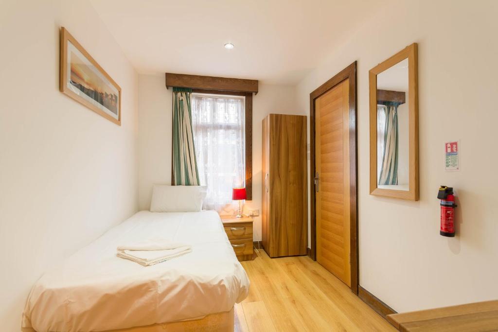 a small bedroom with a bed and a window at Brick Lane Hotel in London