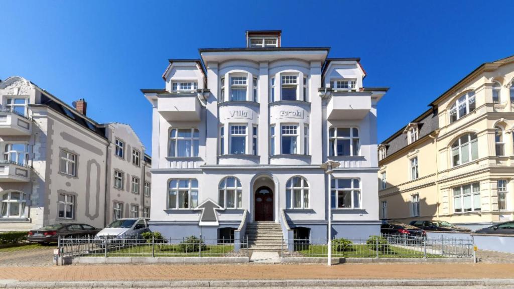 a large white house in the middle of two buildings at Villa Carola - 100 m zum Strand in Heringsdorf