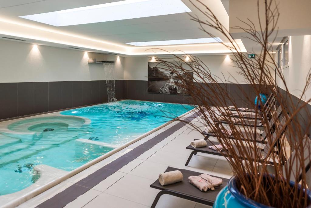 een groot zwembad in een kamer met een groot zwembad bij Villa Italia Luxury Suites and Apartments in Arco