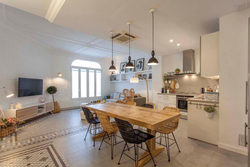 a kitchen and dining room with a wooden table and chairs at Valencia Flat Rental Ensanche 1 in Valencia